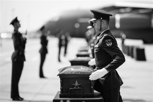 这是在沈阳桃仙国际机场,礼兵将殓放志愿军烈士遗骸的棺椁从专机护送至棺椁摆放区。